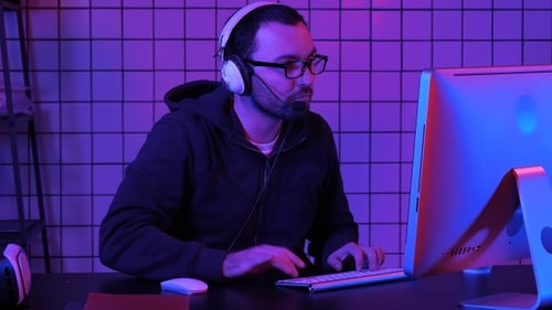 Young Adult Gaming at Computer in Purple Light
