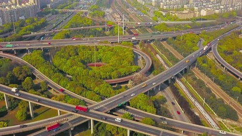 Aerial view of cars on highway junctions with green trees. Bridge roads or streets in structure