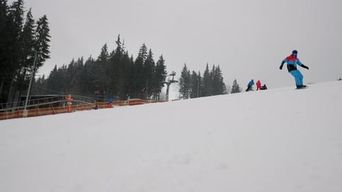 Snowboarder fährt in Zeitlupe in einem Skigebiet bergab Aktive Erholung in den Winterbergen