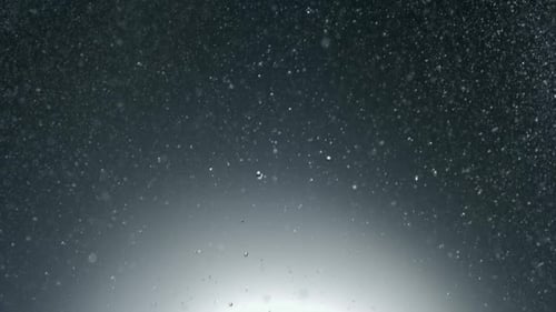 Water Droplets Falling on Gray Background with White Light