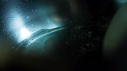 Spoon Stirring Cooking Liquid in Metal Bowl