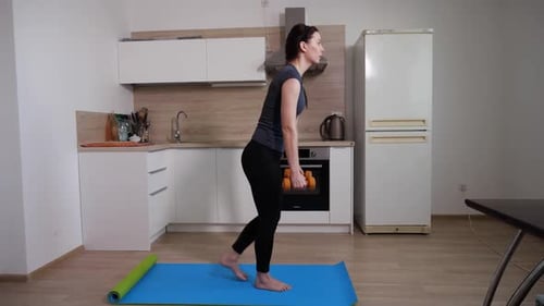Woman Doing Dumbbell Rows in Kitchen