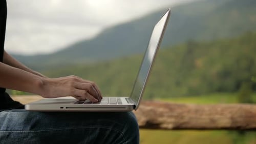 Typing on Laptop Outdoors with Mountain View