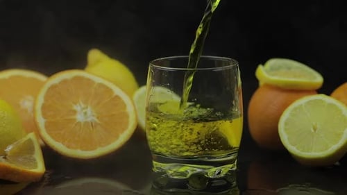 Refreshing Yellow Drink Poured with Citrus Background
