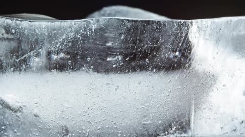 Ice Melts and Rotates on a Black Background