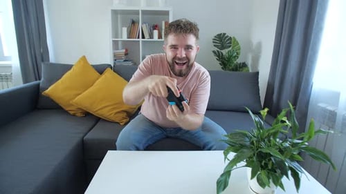 Man Enjoys Video Game on Couch at Home