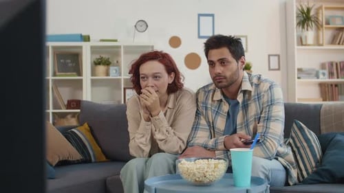 Couple Watching a Scary Movie Together at Home