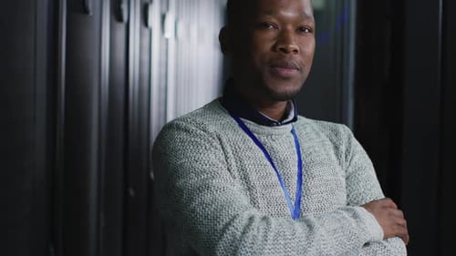 African american male computer technician with security pass in business server room