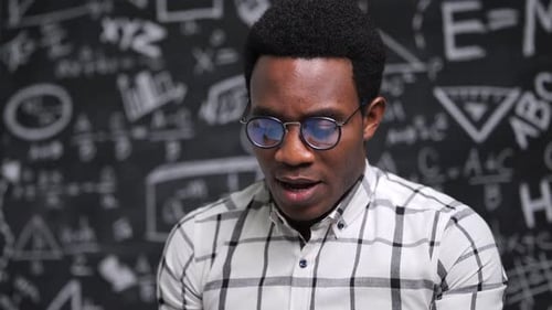 Young Adult Presenting Math Lesson by Blackboard