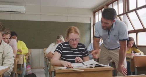 Teacher speaking to a high school student in class