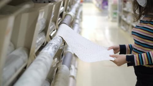 Close Up of Woman Choosing Wallpapers in a Store