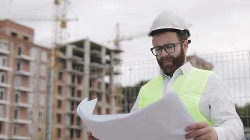 Porträt eines erfolgreichen jungen Ingenieurs oder Architekten mit weißem Helm
