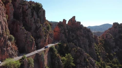 Aerial Shot of Electric Car Driving on the Sunny Road Highway to Mountains Landscape