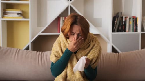 Woman with Flu Symptoms Sits on Couch
