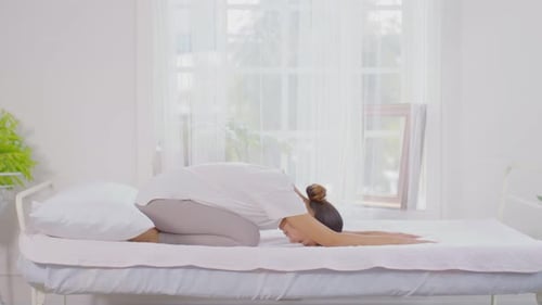 Woman Performs Gentle Yoga Routine on Bed
