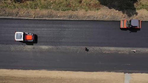 Heavy machinery leveling up new asphalt. Road rollers working on the highway in summer