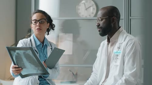 Diverse Doctors Discussing Chest X-Ray during Workday in Clinic