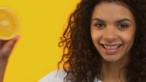 Woman Posing with Orange Half in Studio