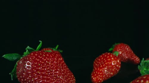 Frische Erdbeeren verteilen sich auf dunkler Oberfläche