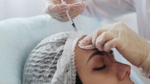 Woman Receiving Cosmetic Injection on Forehead
