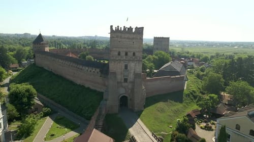 Drone Flies Over Small Medieval Castle on Mountain in Small European City at Sunny Summer Day