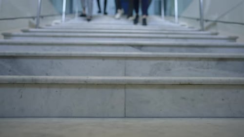 Closeup Stairs in Office with Feet of People Rushing Walking Downstairs