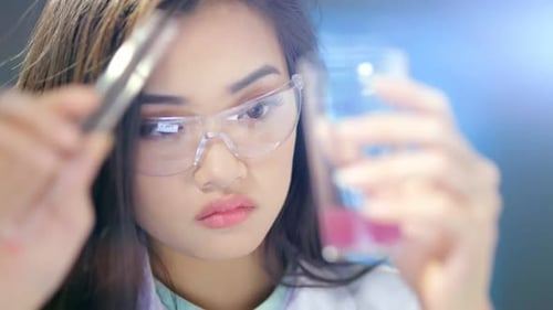 Focused Scientist Examining Test Tube Contents Closely