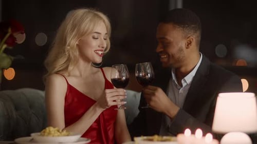 Paar klirrende Gläser trinken Wein und feiern den Valentinstag im Restaurant