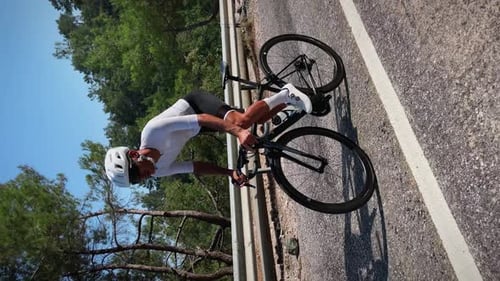 Porträt eines professionellen Radfahrertrainings auf dem Fahrrad in den Bergen, vertikales Video