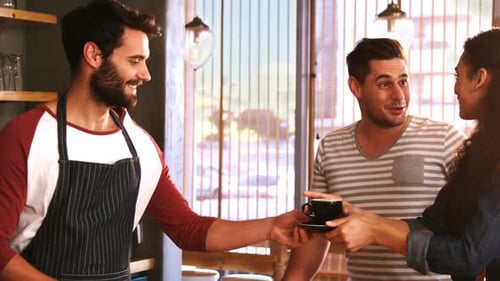 Bearded Barista Serves Coffee to Customers at Cafe