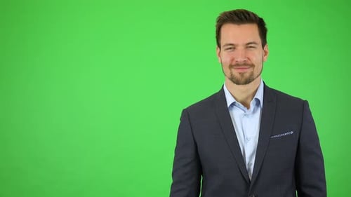 A Businessman Smiles at the Camera, Then Walks Away, Leaving the Frame on the Left - Green Screen
