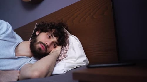 Man Wakes in Bed and Reaches for Cellphone