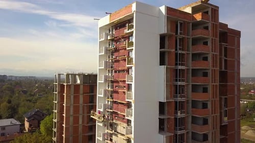 Aerial view of high residential apartment building under construction. Real estate development.