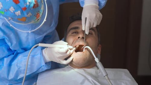 Doctor cleaning teeth.