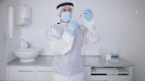 Crop doctor filling syringe with drug in hospital