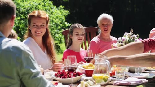 Happy Family Having Dinner Party at Summer Garden
