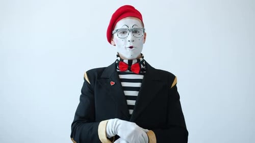 Porträt eines überraschten Mime-Schauspielers, der lächelnd in die Hände klatscht und Daumen hoch