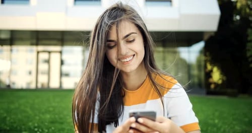 Smiling Woman Using Phone Outdoors