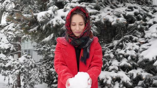 Woman in Red Coat Throws Snow in Winter