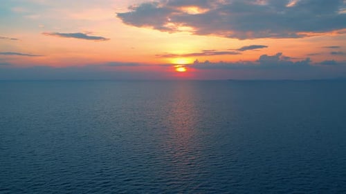 4K-Drohne fliegt über das Meer, Sonnenuntergang am Horizont.