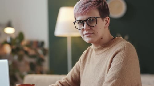 Smiling Young Adult Working at Home on Laptop