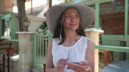 Woman Using Smartphone at Outdoor Cafe Table