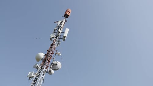 UHF panel and dish antennas on high telecommunication tower slow pan 4K 2160p 30fps UltraHD footage