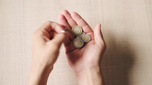 Man counts coins Mexican peso. Poverty and financial crisis in Mexico. Top view. Close up