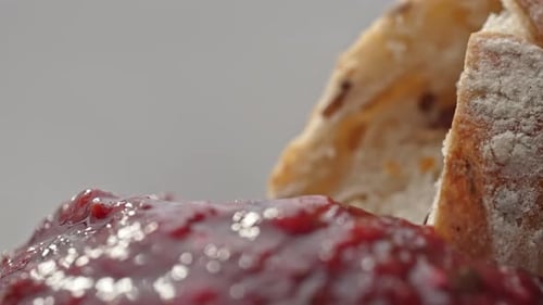 Closeup de embeber pão em geleia de ameixa vermelha
