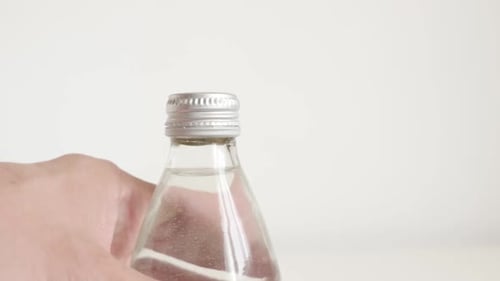 Prendre une bouteille d'eau avec la main (vidéo au ralenti)