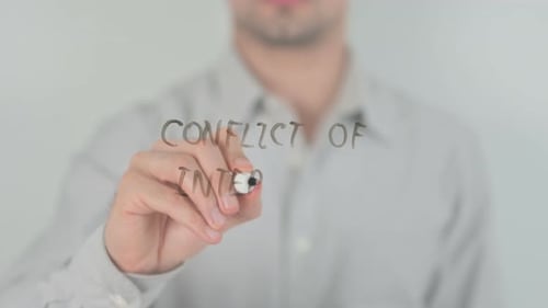 Man Writes Conflict of Interest on Clear Surface