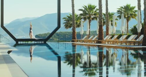 Young lady standing over the pool on holidays. Travel vacation woman relaxing enjoying Montenegro