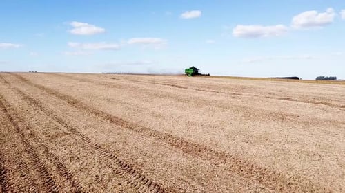 Aerial View of Tractor Harvesting Crops in Field