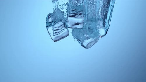 Ice Cubes Splashing into Clear Water